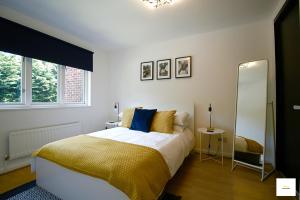 弗里姆利Camberley Spacious and Comfy 3 Bedroom Home, Next to Frimley Hospital with Parking的一间卧室配有一张床和一面大镜子