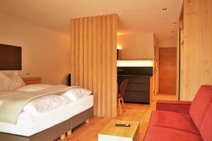 卡斯特尔罗托Kastelart - Karbon的一间卧室配有一张床和一张红色的沙发