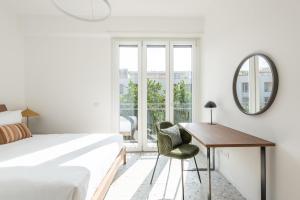 罗马numa I Verso Apartments的一间卧室配有一张床、一张书桌和一面镜子
