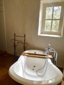MaubecLa Bastide Du Bois Breant的带浴缸的浴室和窗户