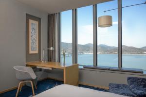 杭州杭州滨江世融艾美酒店的酒店客房设有书桌和窗户。