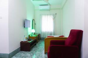 吉大港Hotel Golden Inn Chattagram Ltd的客厅配有红色沙发和红色椅子