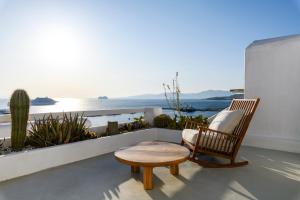 米克诺斯城She Mykonos - The Residency的阳台享有海景,配有椅子和凳子