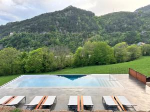 里贝斯的弗里瑟雷斯嘉德德尔温特斯乡村Spa酒店的一个带椅子的游泳池,背景是山脉