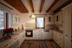 StryszawaPrzytulia willa的一间铺有木地板的大厨房,配有白色的橱柜
