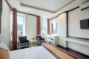 芽庄Minh Tuyết Luxury Hotel managed by HT的酒店客房设有一张床、两把椅子和一扇窗户。