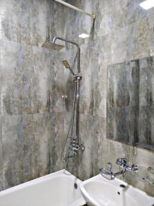 塔什干SAFAR hotel的一间带水槽、浴缸和镜子的浴室
