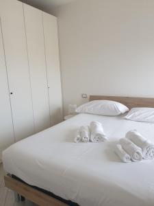 蒙特西尔瓦诺Chez Giulia的一张白色的床,上面有3条滚毛巾