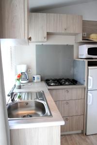 阿格德Camping Resort Les Champs Blancs的厨房配有水槽和炉灶