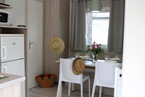 阿格德Camping Resort Les Champs Blancs的厨房配有白色的桌子和白色的椅子