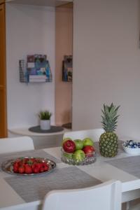 科特卡Araucarias apartment的一张桌子,上面放着一碗水果和 ⁇ 萝