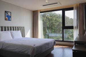 西归浦市Hotel Seogwipean的一间卧室设有一张床和一个大窗户