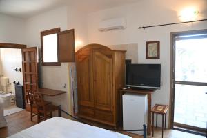 普尔萨诺B&B Villa Dongiovanni的一间设有床、电视和门的房间