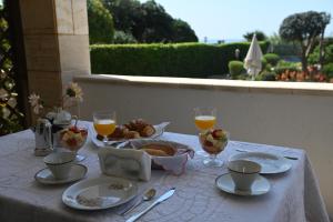 普尔萨诺B&B Villa Dongiovanni的一张桌子,上面放着一盘食物和一杯橙汁