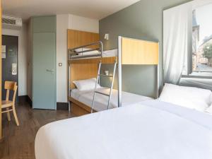 瑟松塞维涅B&B HOTEL Rennes Est Cesson Sévigné的一间卧室配有两张床和一张双层床。