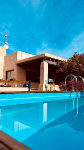 圣费兰-德瑟斯罗Villa Turquoise Formentera的一座带建筑物的房子前的游泳池