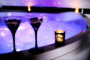 佩皮尼昂Appartement romantique avec jacuzzi et terrasse的两杯酒杯坐在桌子上,放着蜡烛