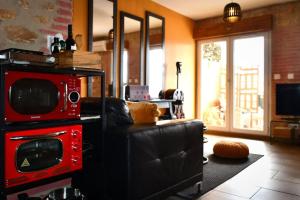佩皮尼昂Appartement romantique avec jacuzzi et terrasse的带沙发和微波炉的客厅