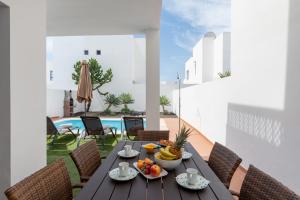 普拉亚布兰卡Luxury 3-bedroom villa with private pool in Marina Rubicon, Playa Blanca, Lanzarote的一个带水果的桌子,阳台上设有游泳池