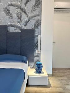 兰佩杜萨BeB Altomare的一间卧室配有一张床,一张蓝色的花瓶放在桌子上