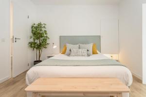 塞图巴尔Setúbal CityCenter Studios的一间卧室配有一张大床和一张木桌