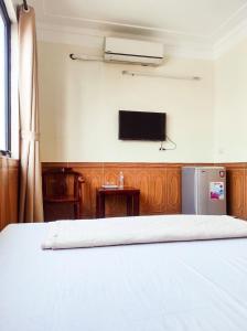 格卢市社Hùng Đức Hotel Cửa Lò的卧室配有一张床,墙上配有电视。