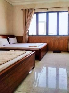 格卢市社Hùng Đức Hotel Cửa Lò的一间卧室设有两张床和大窗户