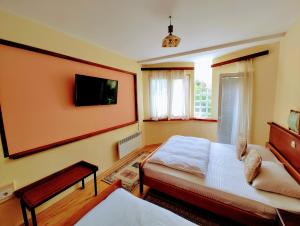 斯科普里卡皮斯特斯科普里酒店的卧室配有一张床,墙上配有电视。