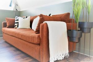 布罗德斯泰17 The Fairways的棕色沙发、枕头和白色毯子