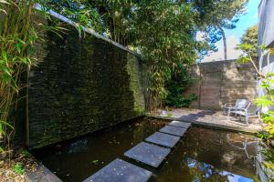 拉波勒花园和Spa贝斯特韦斯特酒店的砖墙前带池塘的花园