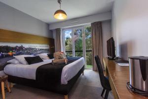 拉波勒花园和Spa贝斯特韦斯特酒店的一间卧室配有一张床、一张书桌和一台电视