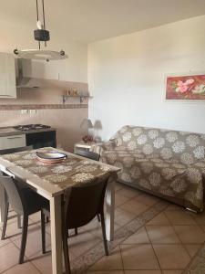 兰佩杜萨Lampedusa Vi attende的厨房以及带桌子和沙发的客厅。