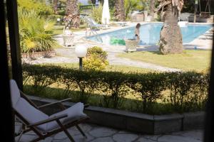 克里皮吉#FLH - Coconut & Vanilla & Pineapple Pool Apartments的游泳池旁几把椅子