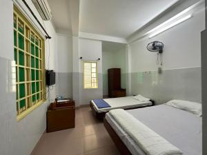 岘港OYO 1182 An Binh Motel的一间卧室配有两张床和电视。