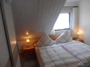 比苏姆Haus-Lily-Nr-03的一间卧室配有一张带两张台灯的床铺。