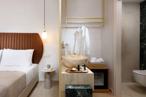 斯卡拉拉乔伊Hotel Villa Natassa的一间卧室配有一张床和一个水槽和一个浴缸