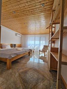 苏利纳Casuta Noastra - Sulina的一间卧室设有一张床和木制天花板