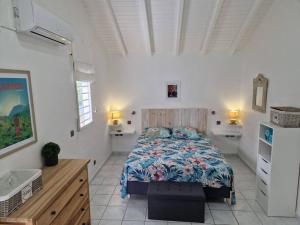 路易港Villa Eden, à 400 mètres de la plage du Souffleur的一间白色客房内的床铺卧室