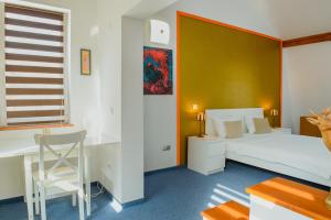 锡比乌圣马丽亚别墅式酒店的一间卧室配有一张床、一张桌子和一把椅子