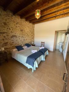 马拉加Habitacion rural en Alora Caminito del Rey的一间卧室设有两张床和石墙