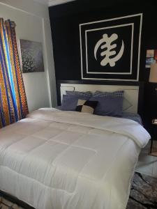 阿克拉KESEWAA's APARTMENT的卧室配有带蓝色枕头的大型白色床