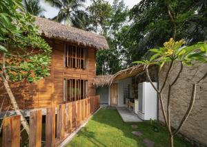 巴图卡拉Cay's House Batukaras的茅草屋顶和庭院的房子