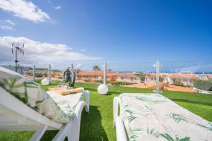 卡亚俄萨尔瓦赫5 bedrooms villa La Laja的天井在草地上摆放着两把白色椅子