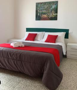 里米尼Hotel Migani的一间卧室配有一张带红色枕头的大床