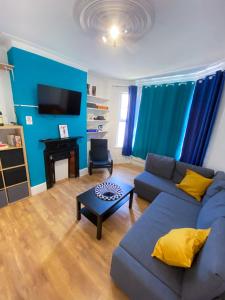 伦敦4 BEDROOM HOUSE PARKING & GARDEN NEAR CENTRAL LONDOn的蓝色的客厅配有沙发和桌子