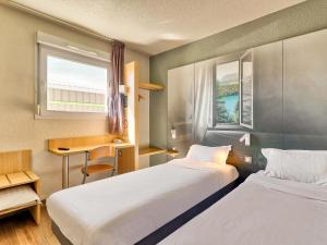 奥比埃B&B HOTEL Clermont-Ferrand Sud Aubière的酒店客房设有两张床和窗户。