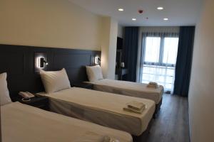 伊斯坦布尔Shishly Palace Hotel的酒店客房设有两张床和窗户。