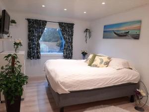 格里姆斯塔Cosy family home with pool的一间卧室设有一张大床和一个窗户。