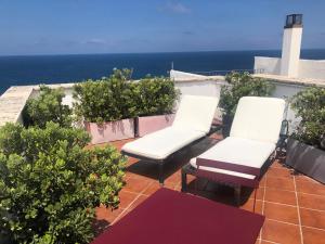 滨海波利尼亚诺La Torretta del Senatore的阳台上配有两把椅子和一张桌子,享有海景