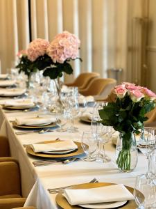 比亚韦斯托克皇家酒店及Spa的长桌,带花的盘子和花瓶